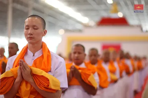 Newly ordained monks seated together at a mass ordination ceremony